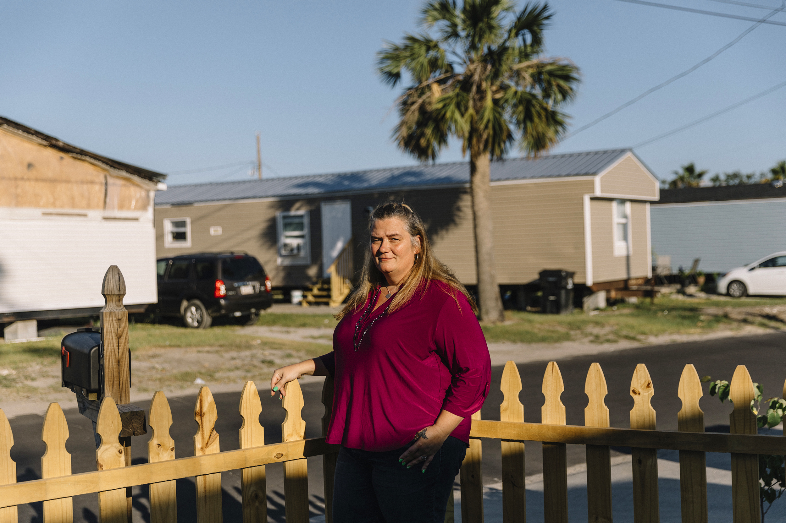 Christina Harding stands in front of the Habitat for Humanity home where she's lived since 2016 in Panama City, Fla. Last year Harding rode Hurricane Michael with her family in the house. Much of her neighborhood still shows signs of massive damage. (William Widmer for NPR)