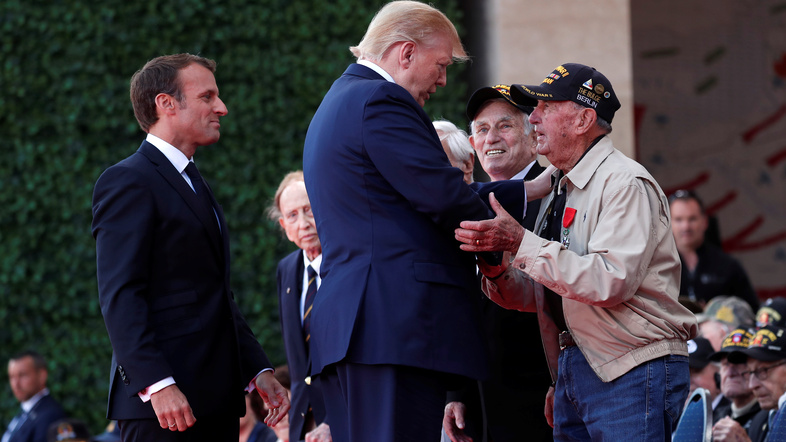 President Trump and French President Emmanuel Macron greet a U.S. veteran during the D-Day commemoration at the Normandy American Cemetery and Memorial in Colleville-sur-Mer, France. (Ian Langsdon/Reuters)
