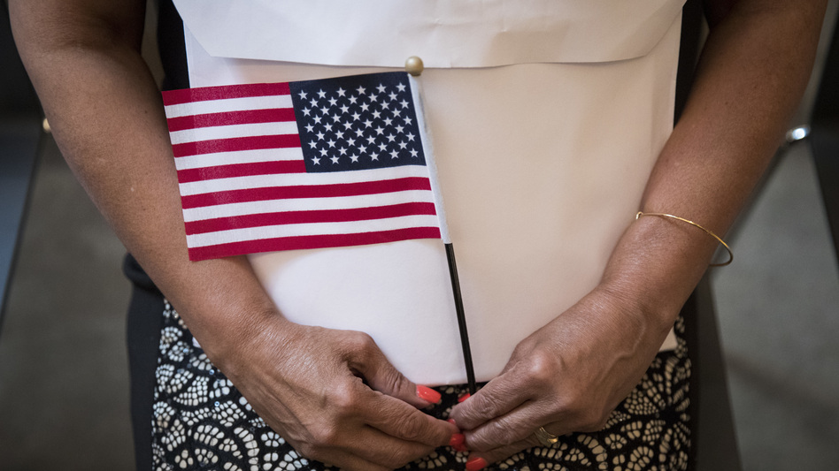 A participant in a 2018 naturalization ceremony holds a U.S. flag in New York City. Research by the Census Bureau suggests the citizenship question is highly likely to scare households with noncitizens from taking part in the constitutionally mandated head count. (Drew Angerer/Getty Images)