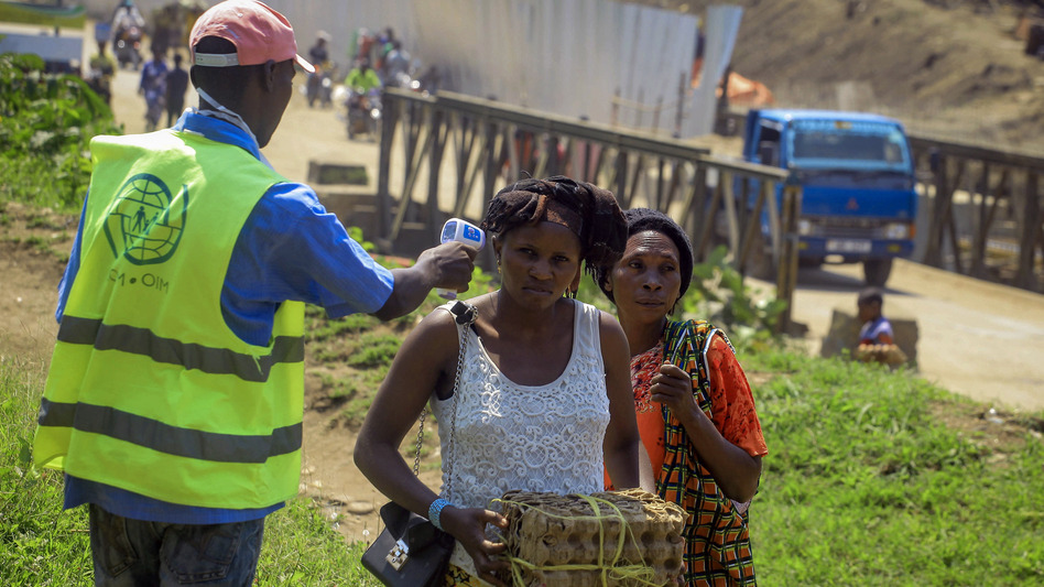 Uganda has reported its first death from Ebola. Here, a health worker takes a woman's temperature at a border crossing between Uganda and Democratic Republic of the Congo, part of an effort to screen for Ebola and prevent its spread. (Al-hadji Kudra Maliro/AP)