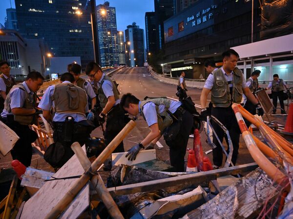 Police officers on Thursday dismantle barricades placed earlier by demonstrators in Hong Kong.