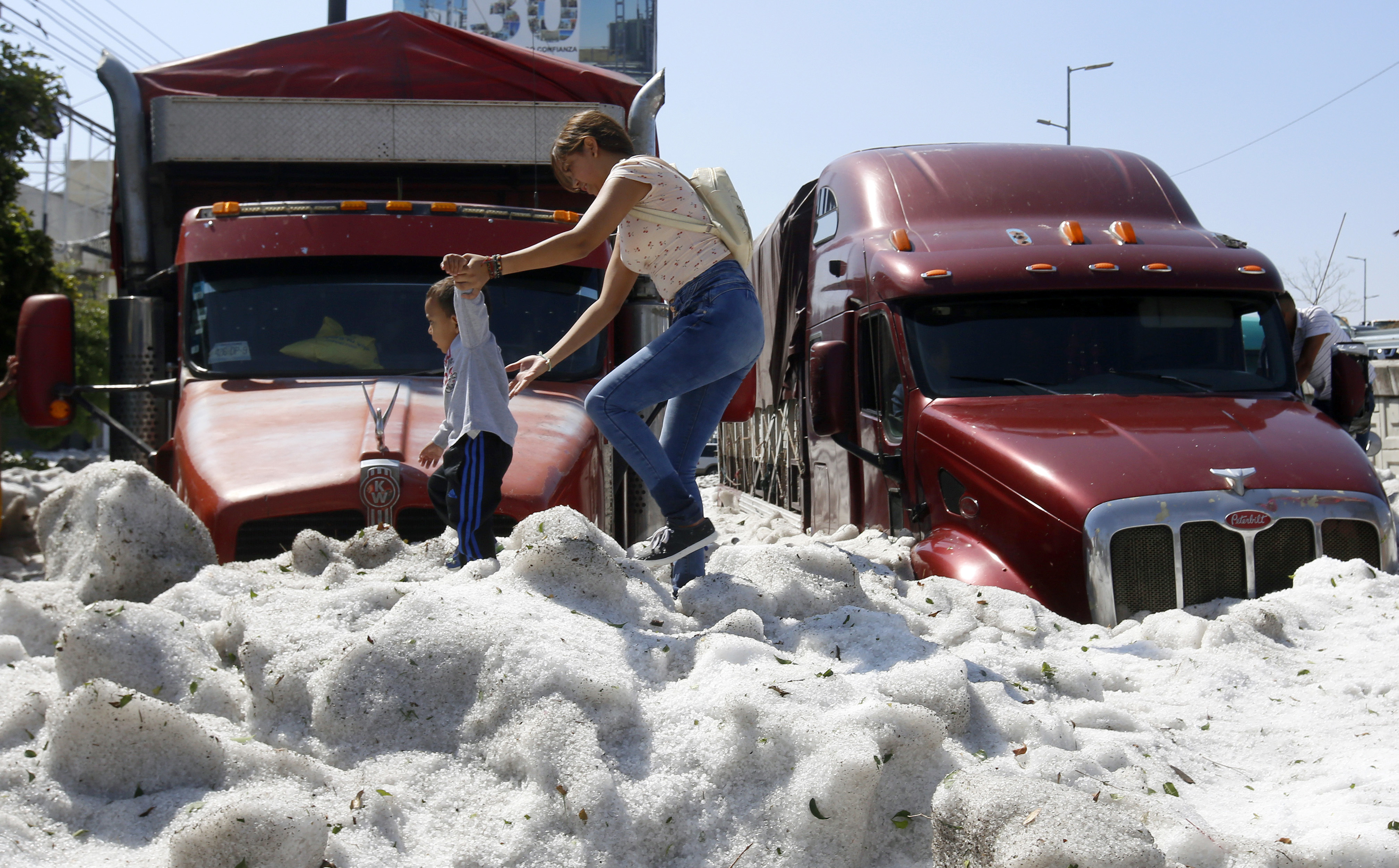 A woman and a child walk on hail in eastern Guadalajara on Sunday.