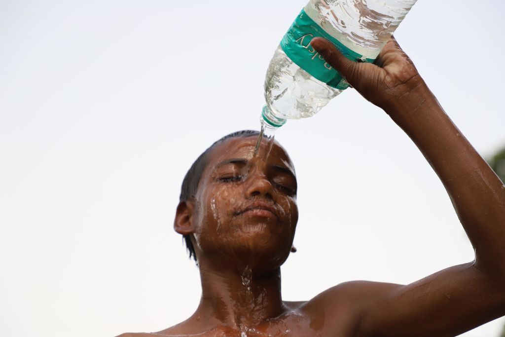 A kid tries to beat the heat in New Delhi on June 15. The changing climate is especially brutal in India. Temperatures are soaring. Asphalt roads are melting. People are dying. (NurPhoto via Getty Images)