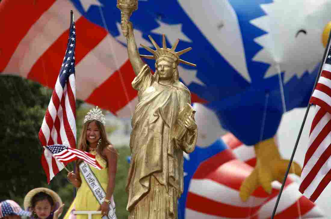 A golden depiction of the Statue of Liberty and "Miss VietFest United States" are seen during the National Independence Day Parade.