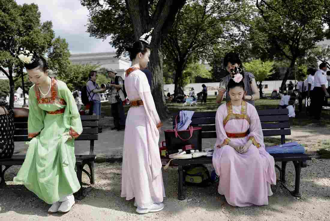 Women in festive clothing get ready during the National Independence Day Parade festivities.