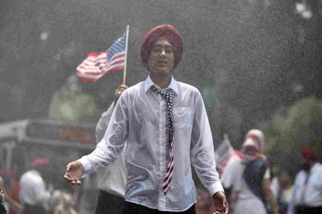 A man wearing a stars-and-stripes tie is drenched in rain during the National Independence Day Parade.