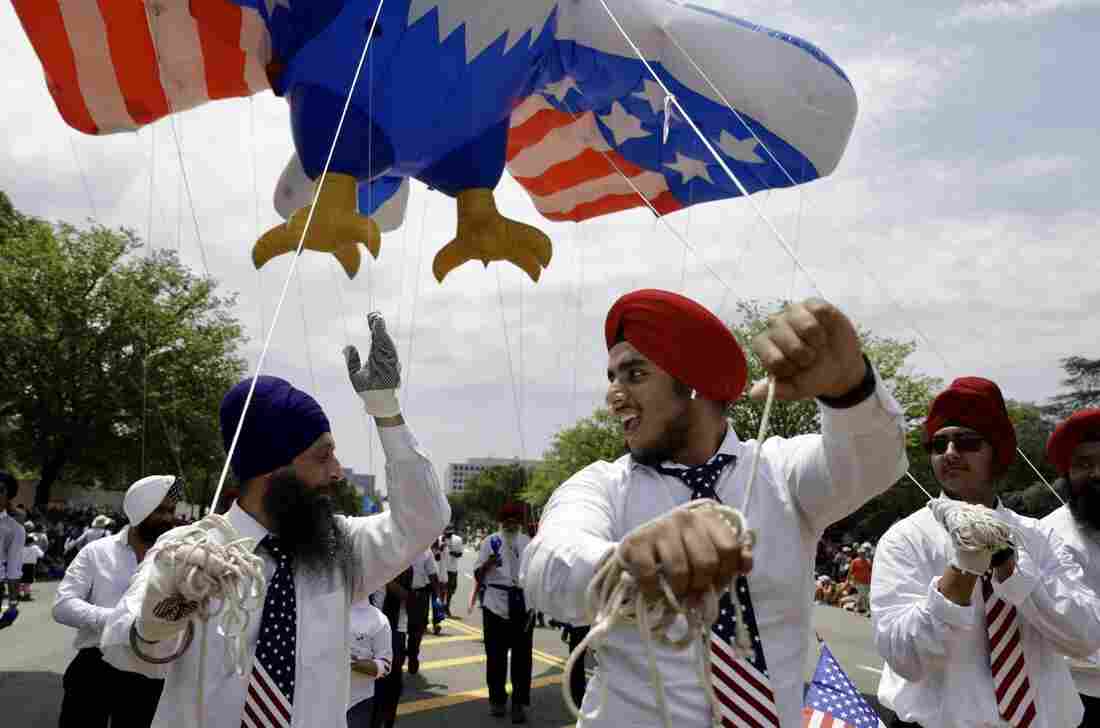 Men celebrate while holding onto a red, white and blue eagle balloon overhead during the National Independence Day Parade.