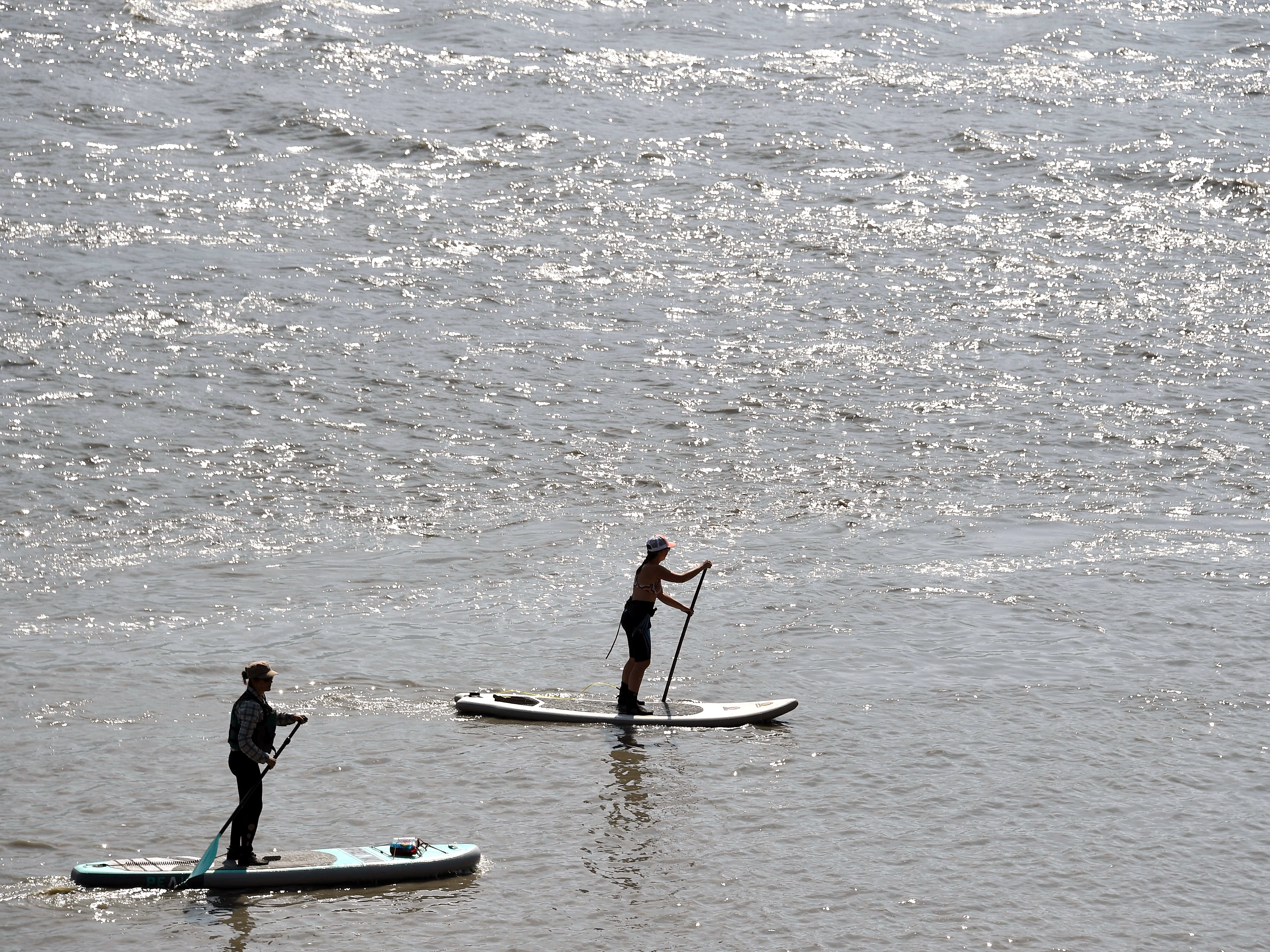 Two women navigate the Turnagain Arm on paddleboards on Thursday south of Anchorage, Alaska, amid temperatures that hit 90 for the first time ever. The new high was recorded at Ted Stevens Anchorage International Airport.