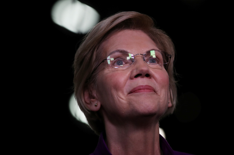 Sen. Elizabeth Warren, D-Mass., speaks to the media in the spin room after the first night of the Democratic presidential debate in Miami last month. (Drew Angerer/Getty Images)