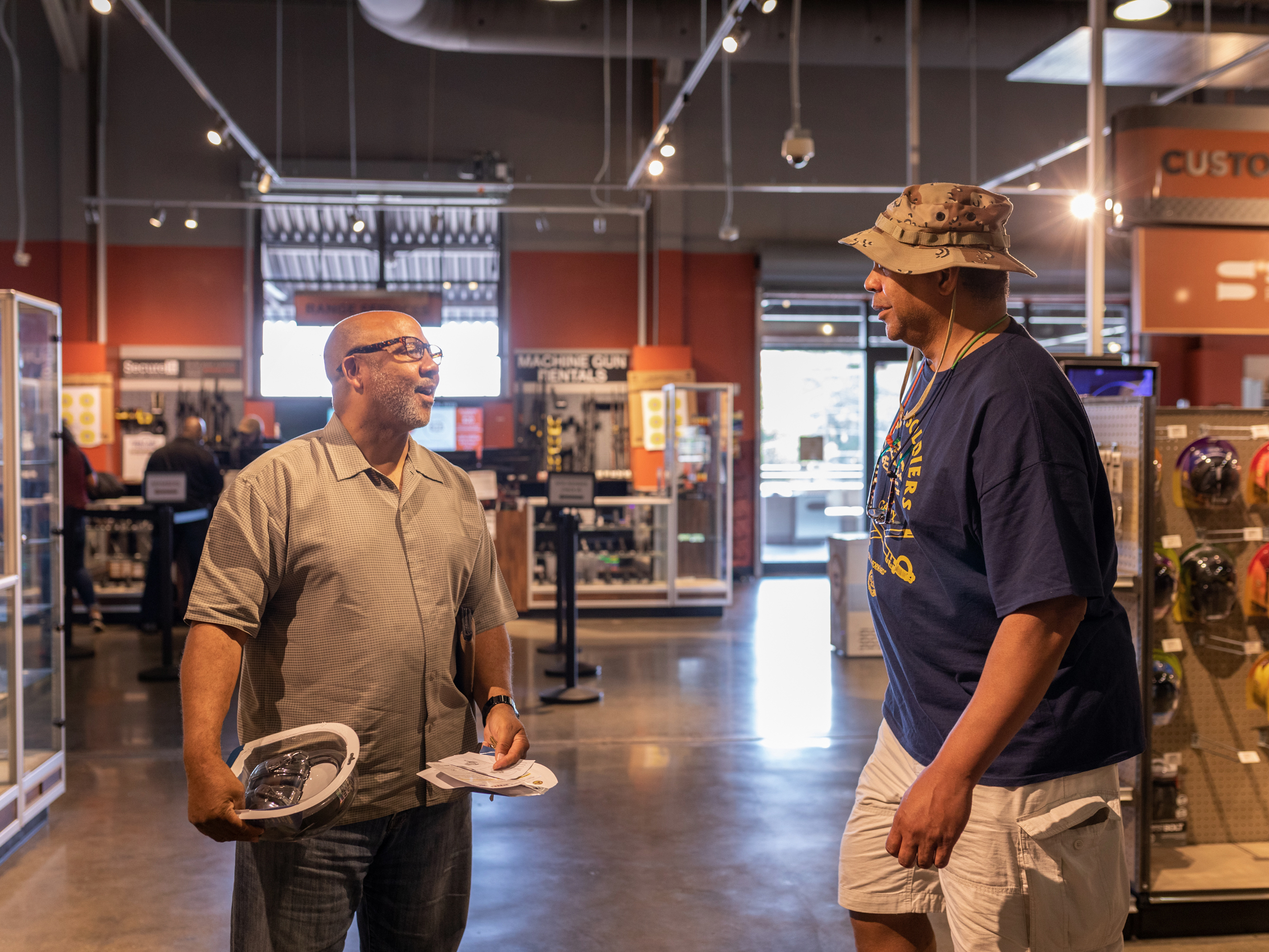 NAAGA president Philip Smith and Davis Nelson, a member of the Atlanta chapter, talk in the show room of Stoddard's  Range and Guns. Smith and others in the organization say the group is supportive of law enforcement. But also points out that carrying a gun while black can be seen as threatening by others, including police.