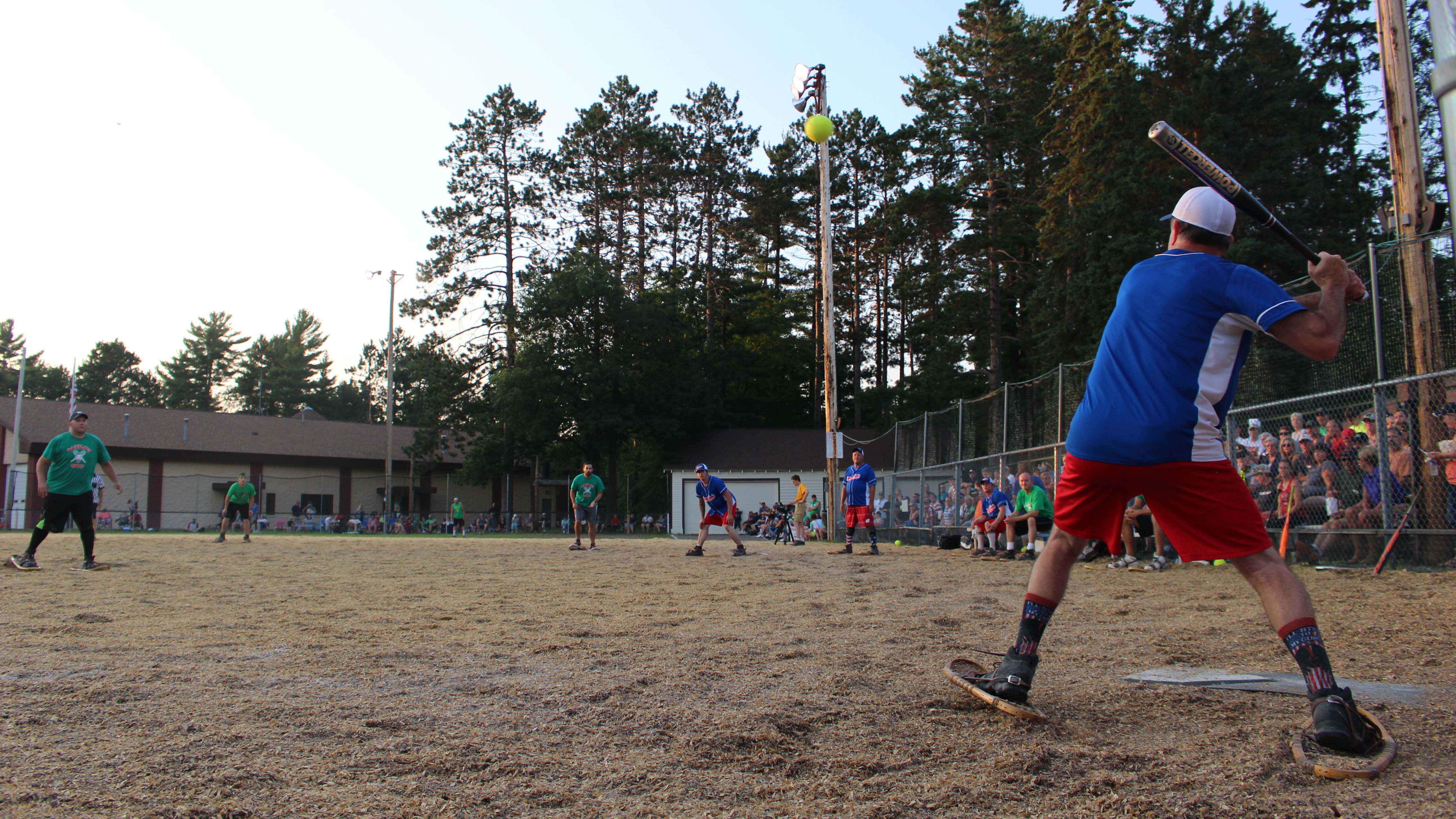 Huge crowds turn up each week to watch a game of baseball on a woodchip field, where the players wear snowshoes.