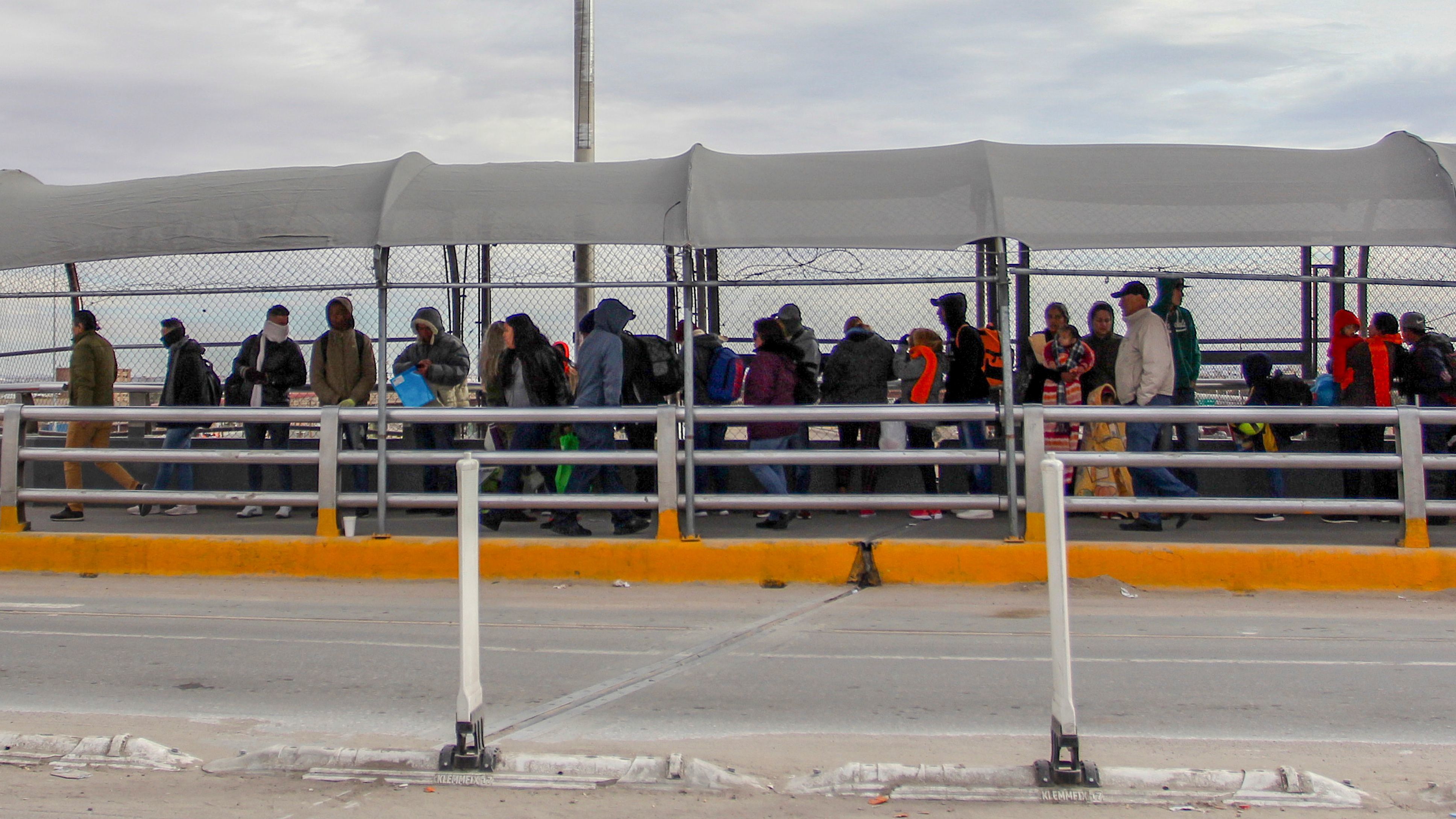 Migrants line up at the Paso del Norte International Bridge in Ciudad Juarez, Mexico, waiting to cross the border and request asylum in January. Thousands of asylum-seekers are waiting in Mexican border cities like Juarez right now, hoping for their turn to legally cross the border and make their case in court. (AFP/Getty Images)