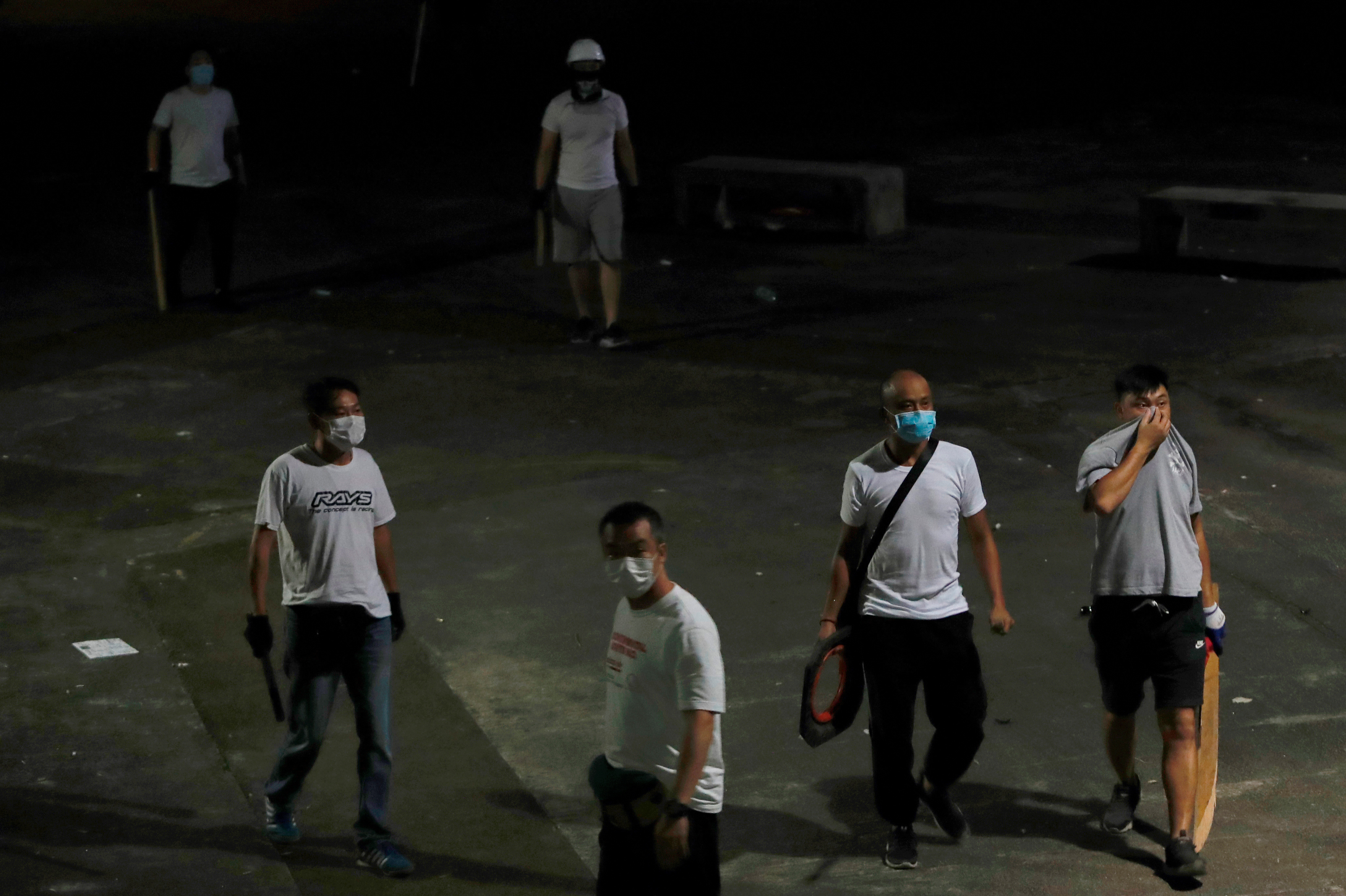 Men in white T-shirts with poles are seen in Yuen Long after clashing with anti-extradition bill demonstrators at a train station in Hong Kong. (Reuters)