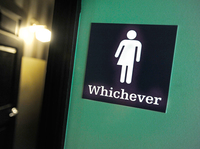 A gender neutral sign is posted outside a bathrooms at Oval Park Grill in Durham, N.C. Many North Carolina businesses put gender neutral signs on toilets after the "bathroom bill" was passed.