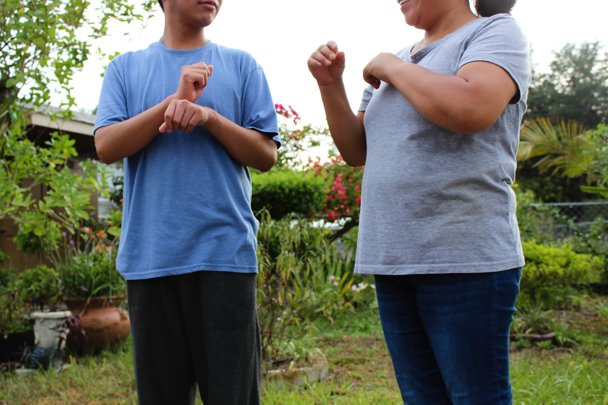 A Guatemalan teen asylum-seeker (left), who isn't able to hear or speak, signs with his mom in Florida. He was brusquely separated from her and held in a shelter for nearly three months, unable to readily communicate, according to a civil rights complaint filed with the Department of Homeland Security. (Susan Ferriss/Center for Public Integrity)
