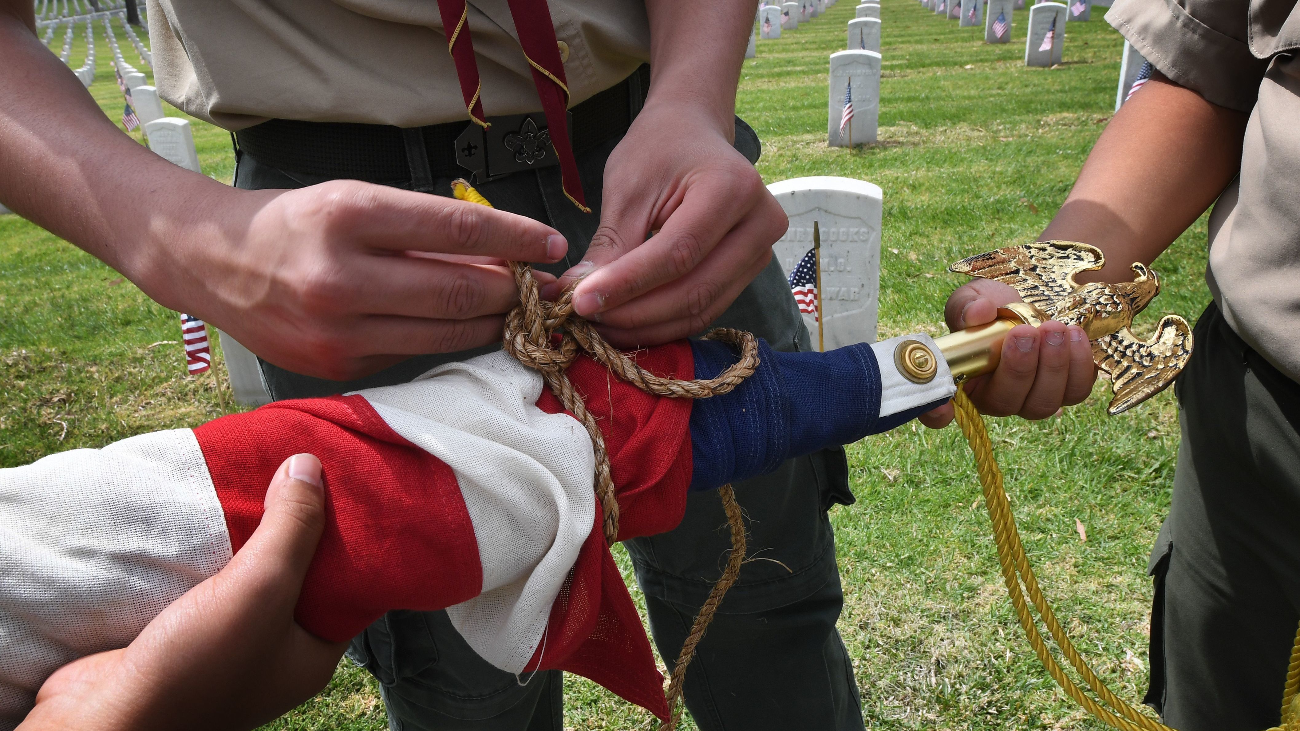 Boy Scouts at Los Angeles National Cemetery prepare a U.S. flag beside the graves of war veterans on May 25, during the annual flag placement ceremony for Memorial Day to honor the fallen. (AFP/Getty Images)