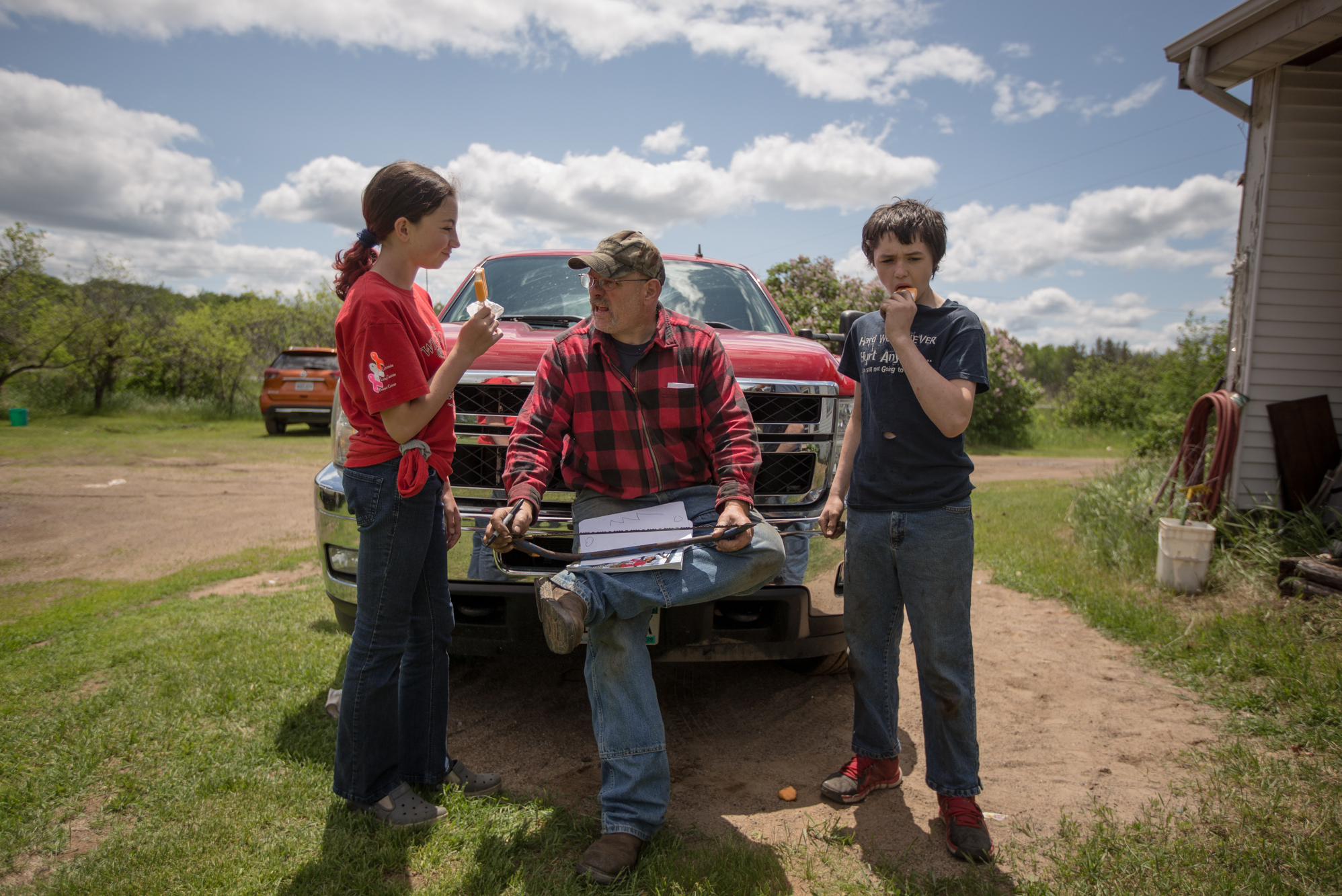 Daryl Doering (center) of Kids Plus explains how certain yard tools work to volunteers Amelia Seybold (left) and Jason Ponthieux during a popsicle break at Barbara Coplan's house. Kids Plus connects kids with adults and seniors to foster relationships in the community.