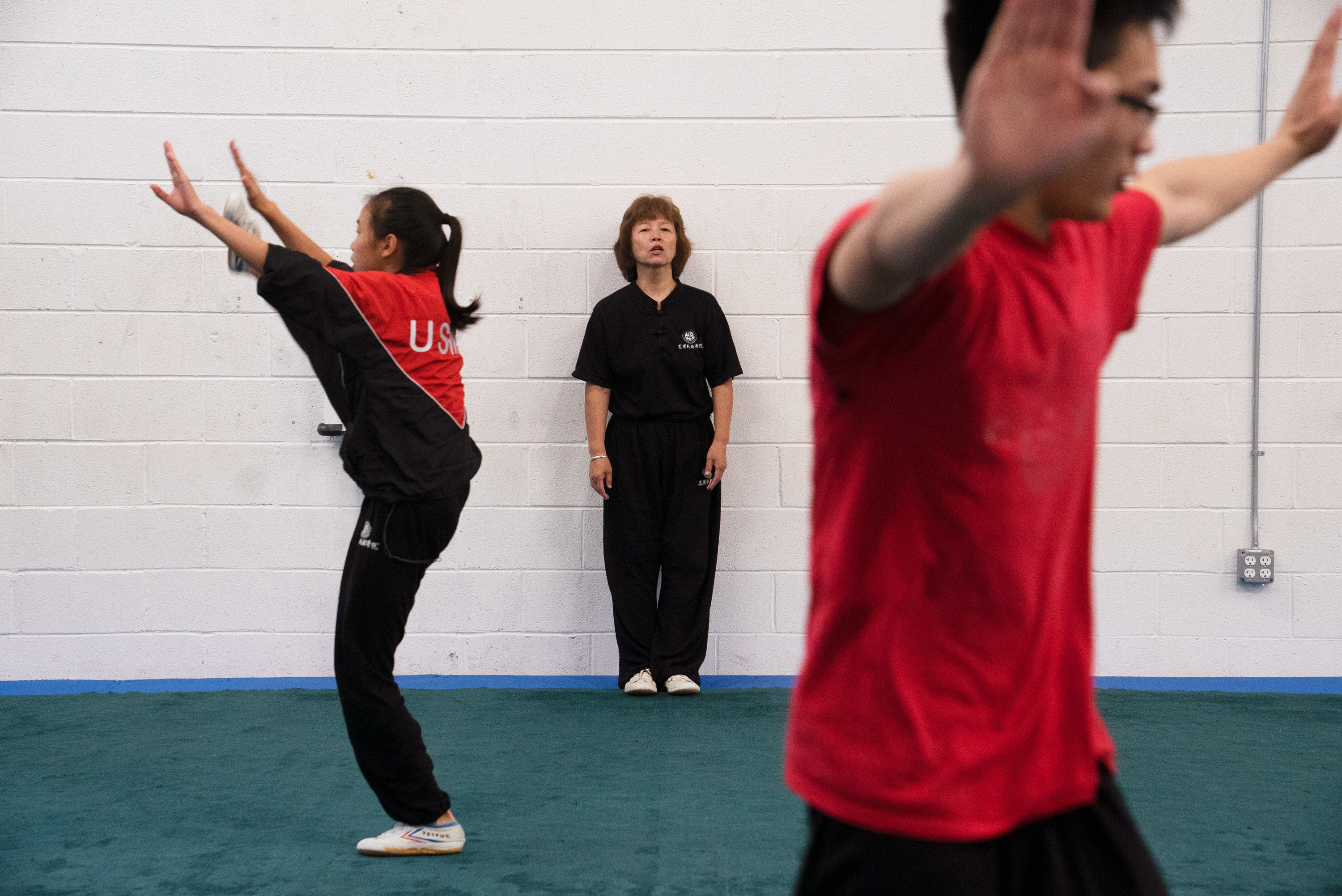 Wushu Coaches Help Chinese Students Master Literacy And 'Become A Better Person' 4 Zhang coaches from the sidelines as students stretch before practice.