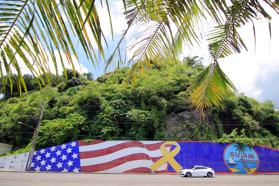 Afternoon traffic passes in front of a mural depicting the U.S. and Guam flags in the Tumon district on the island of Guam. (Virgilio Valencia/AFP/Getty Images)