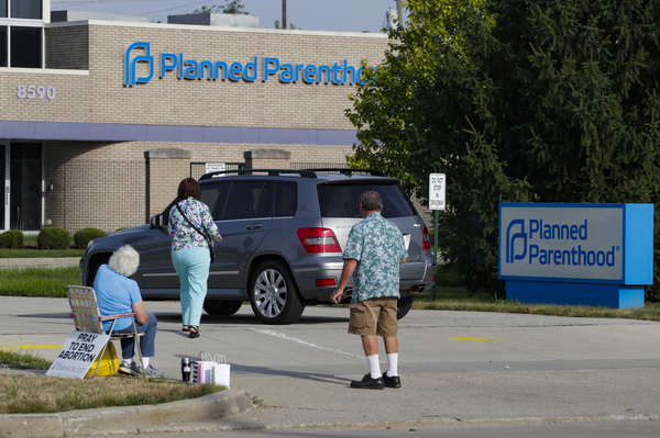 Abortion protesters attempt to hand out literature as they stand in the driveway of a Planned Parenthood clinic in Indianapolis on Aug. 16.