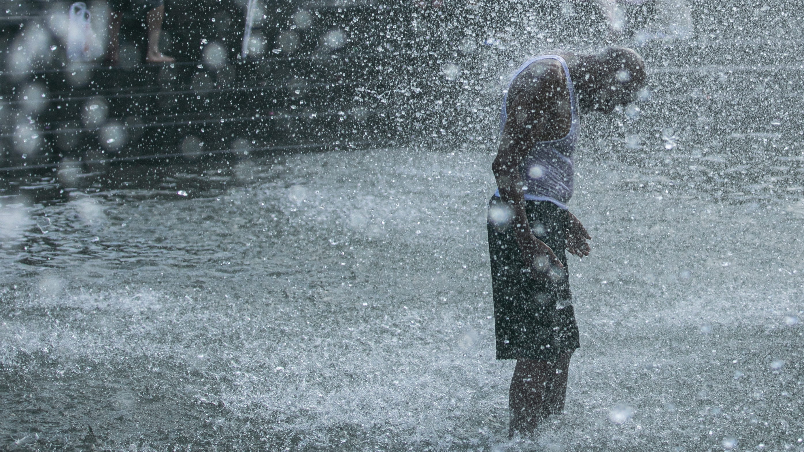 A man cools off in a fountain in New York