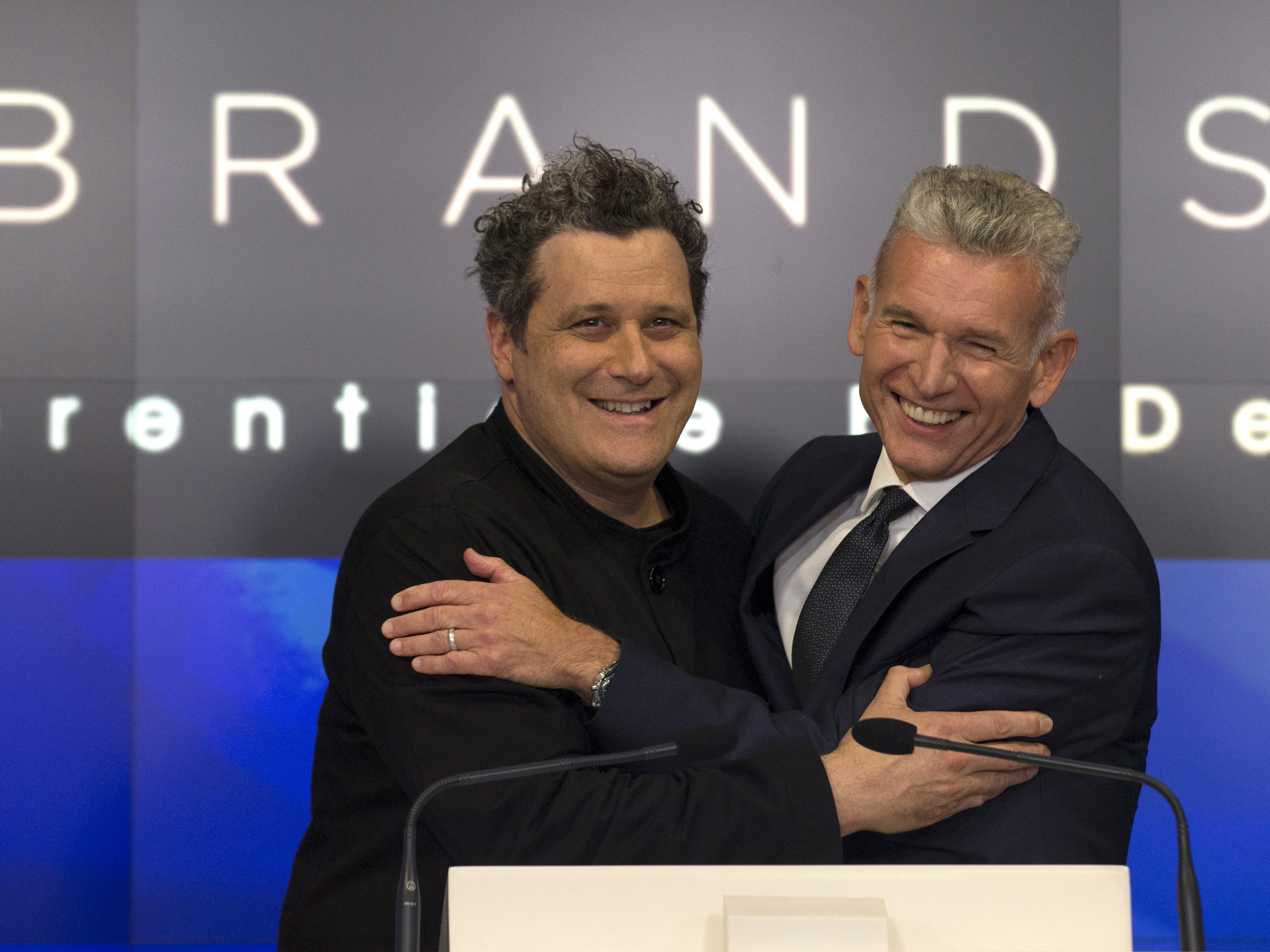 Designer Isaac Mizrahi (left) embraces Robert D'Loren, CEO of Xcel Brands, which once manufactured 70% of its clothes in China. Today that's down to about 20%. The company now manufacturers in a variety of countries, including Indonesia, India and Sri Lanka. (Reuters)