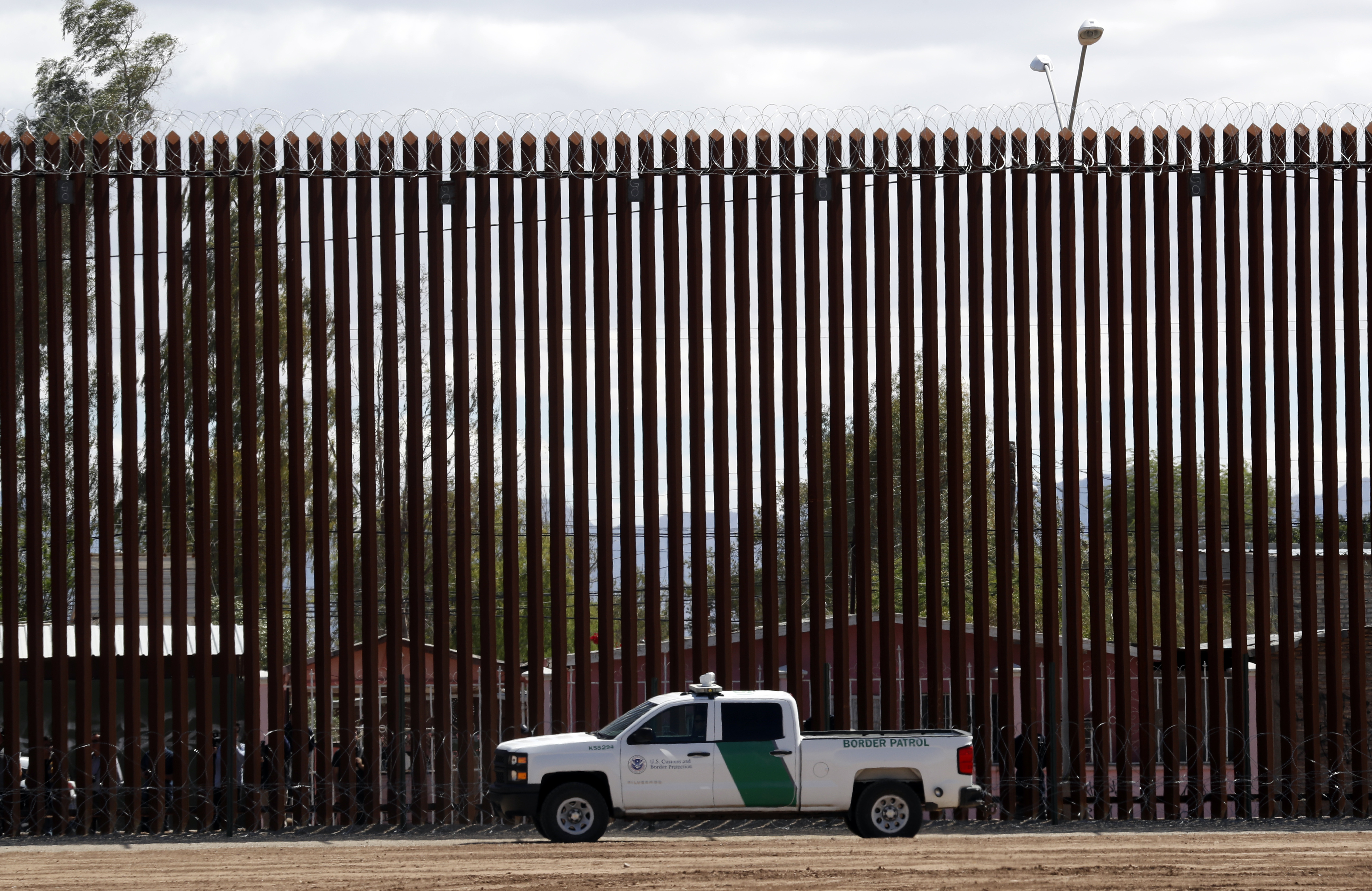 A U.S. Customs and Border Protection vehicle sits near the wall as President Donald Trump visits a new section of the border wall with Mexico in El Centro, Calif., on April 5. This area is one where the Pentagon will spend more resources shifted away from military construction projects.