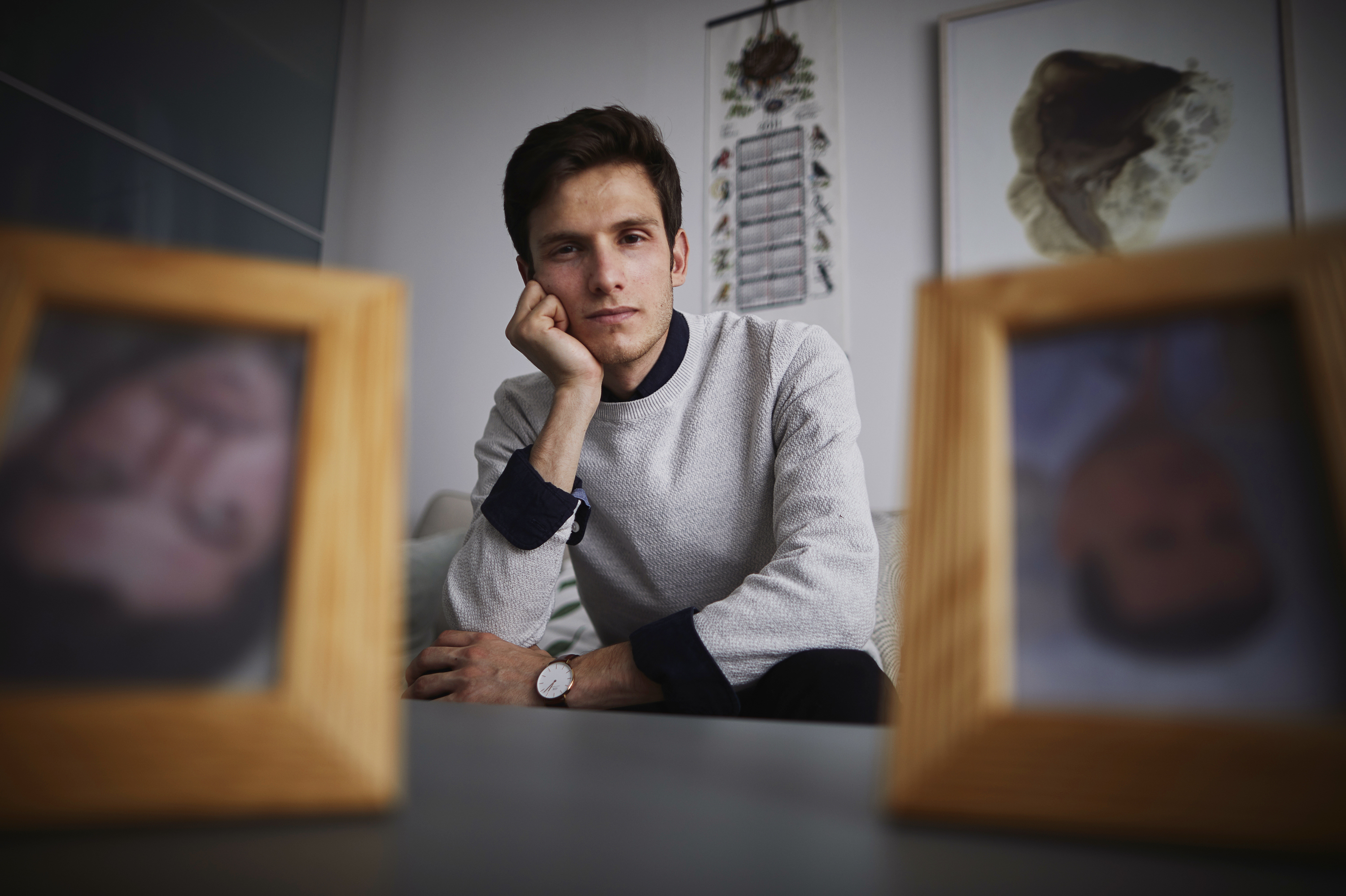 Omar Alshogre, a Syrian refugee who was tortured as a political prisoner in Syria, now lives in Sweden. He has framed photos of men who he says tortured him that he keeps upside down. (Axel Öberg for NPR)