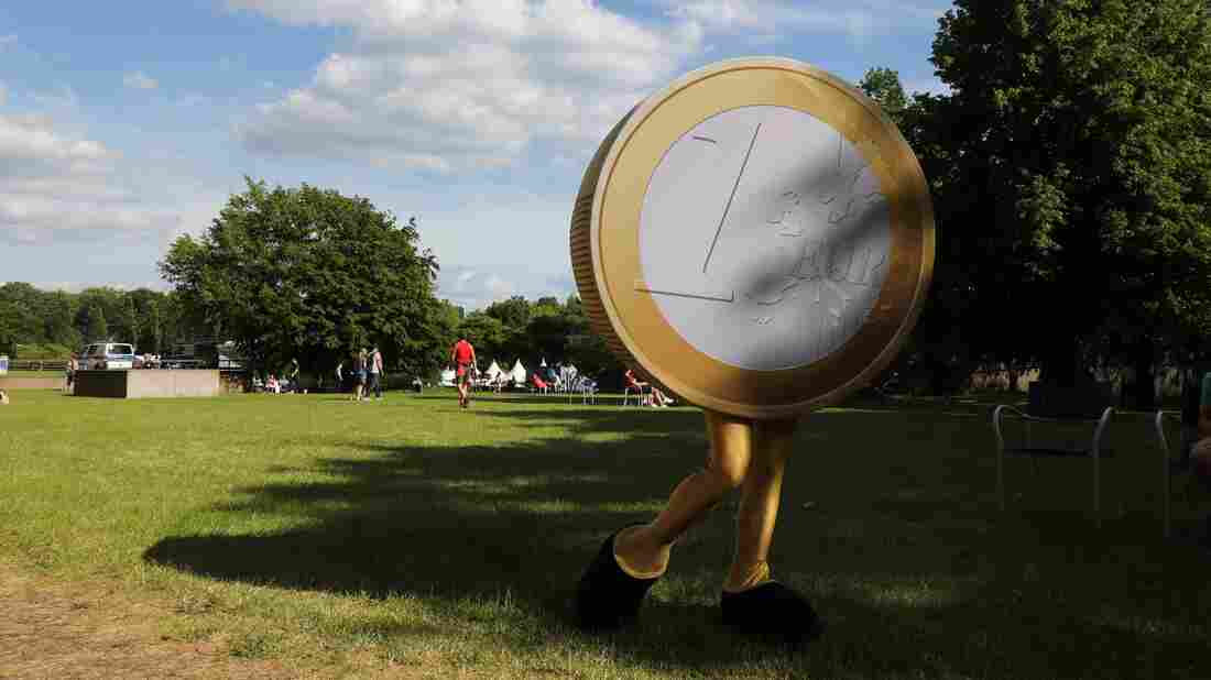 This picture taken on May 26, 2019, shows a person dressed as an euro coin in the garden of the German federal bank in Frankfurt am Main, western Germany.