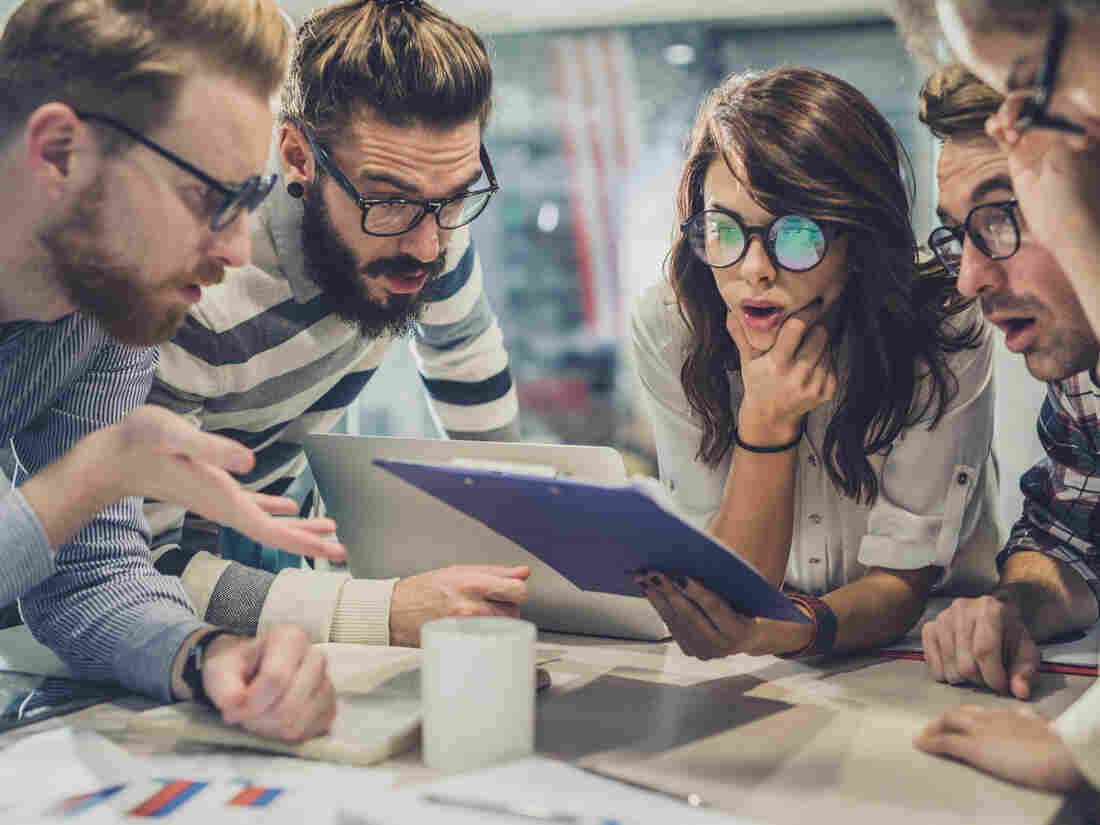 Group of shocked business people with eyeglasses reading documents in the office. (Source: Getty Images)