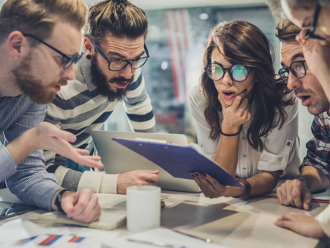 Group of shocked business people with eyeglasses reading documents in the office. (Source: Getty Images)