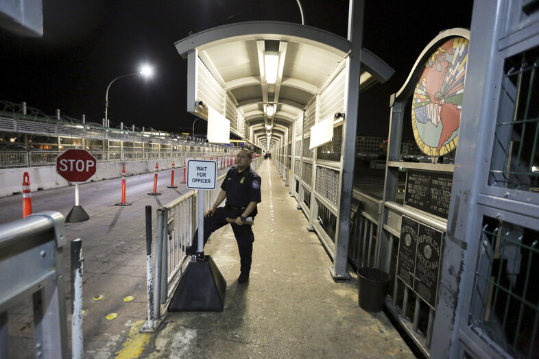 A U.S. Customs and Border Protection officer waits for migrants who are applying for asylum in the U.S. to arrive at International Bridge 1 where they will cross from Nuevo Laredo, Mexico, to Laredo, Texas, early Sept. 17, 2019. (Fernando Llano/AP)
