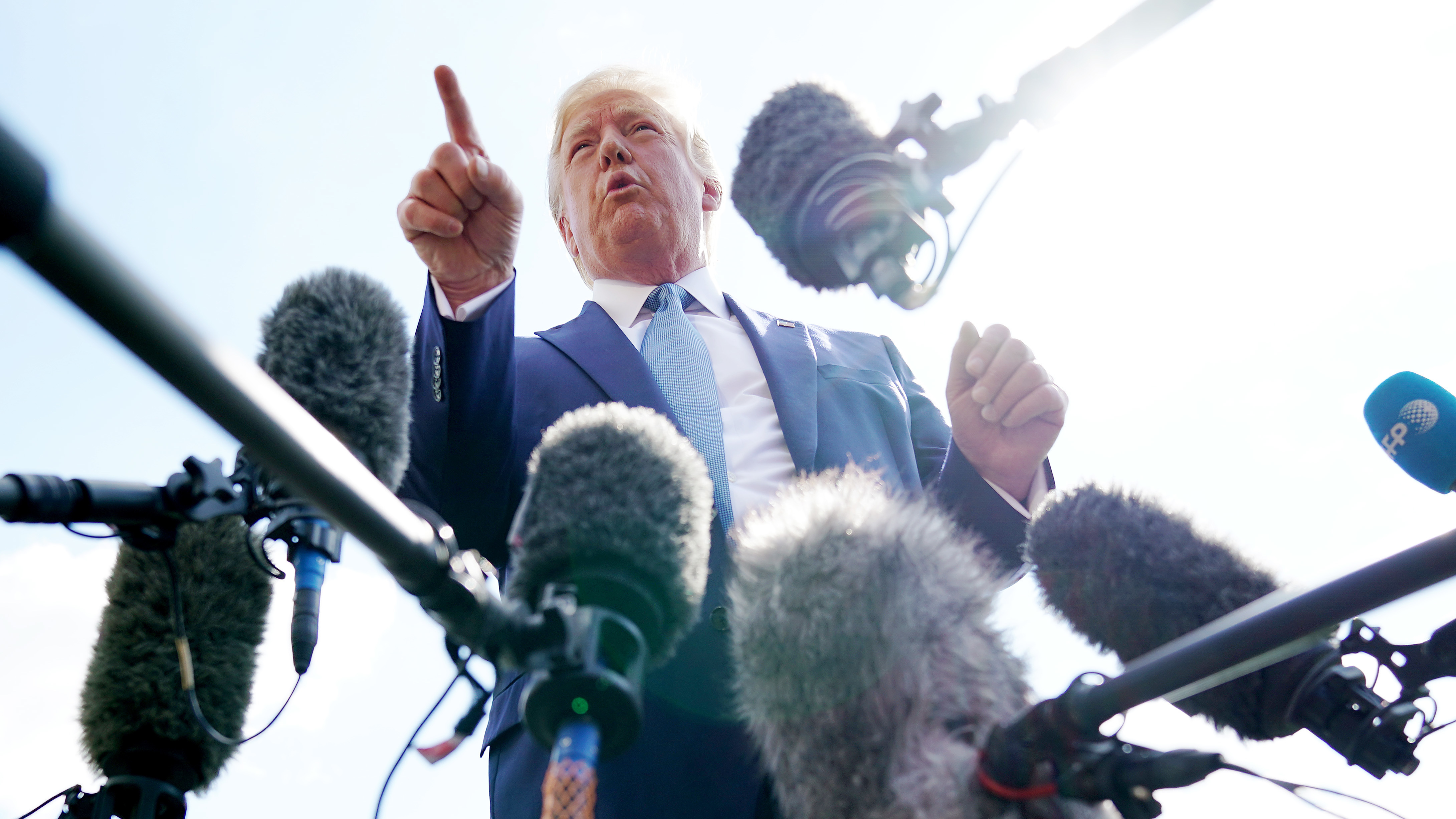 President Trump talks to journalists on the South Lawn of the White House Friday. An NPR analysis finds Trump's use of heated phrases has jumped considerably beginning in March of this year. (Getty Images)