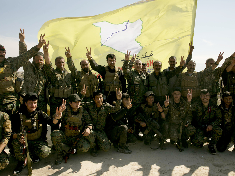 U.S.-backed Syrian Democratic Forces (SDF) fighters pose for a photo in Baghouz, Syria, in March after the SDF declared the area free of Islamic State militants. (Maya Alleruzzo/AP)