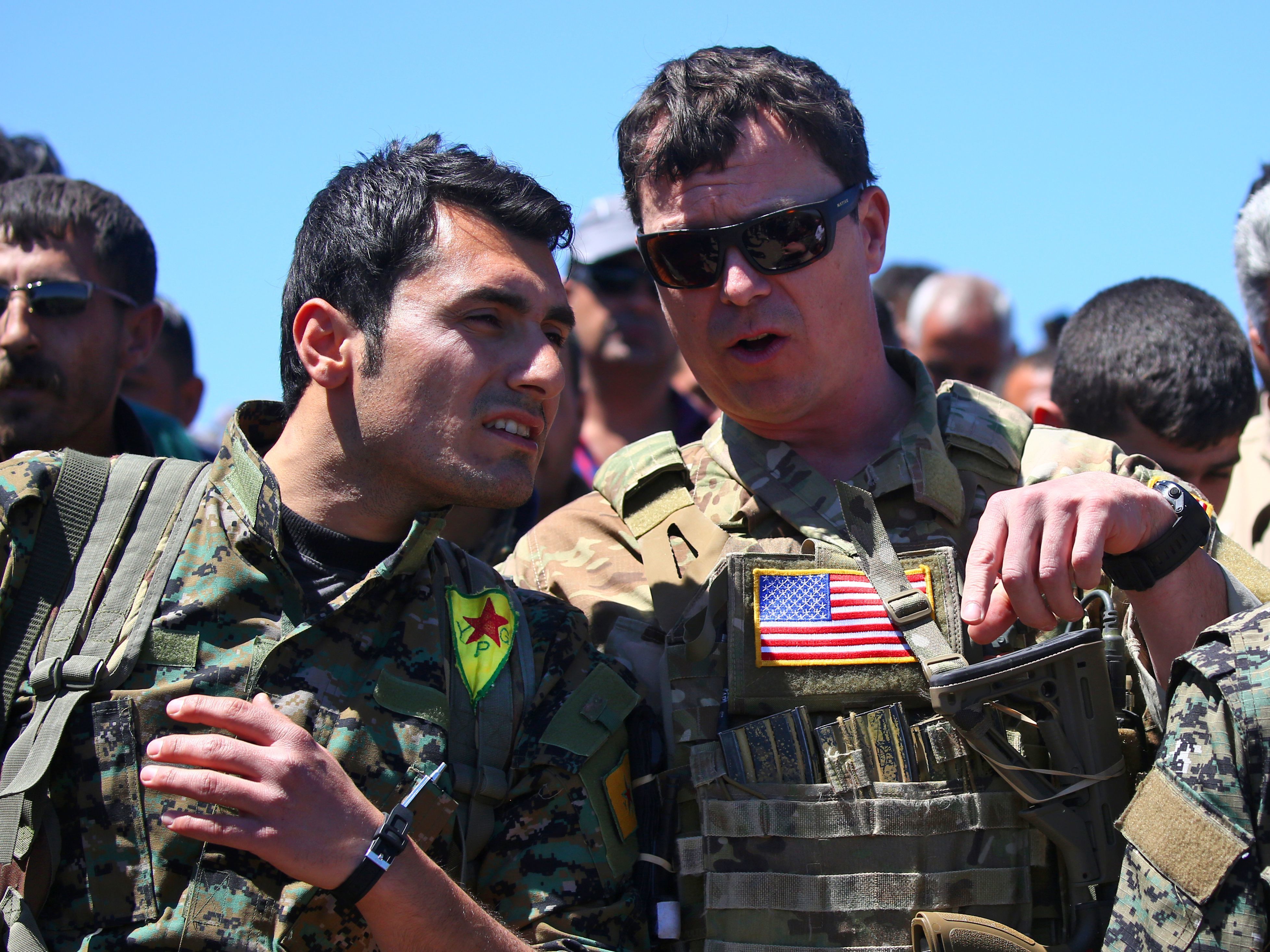 President Trump's plan for the Turkish-Syrian border contradicts recommendations from top officials in the Pentagon and the State Department. In this 2017 photo, a U.S. officer from the coalition against ISIS speaks with a fighter from the Kurdish People's Protection Units (YPG) at the site of Turkish airstrikes near the northeastern Syrian Kurdish town of Derik.