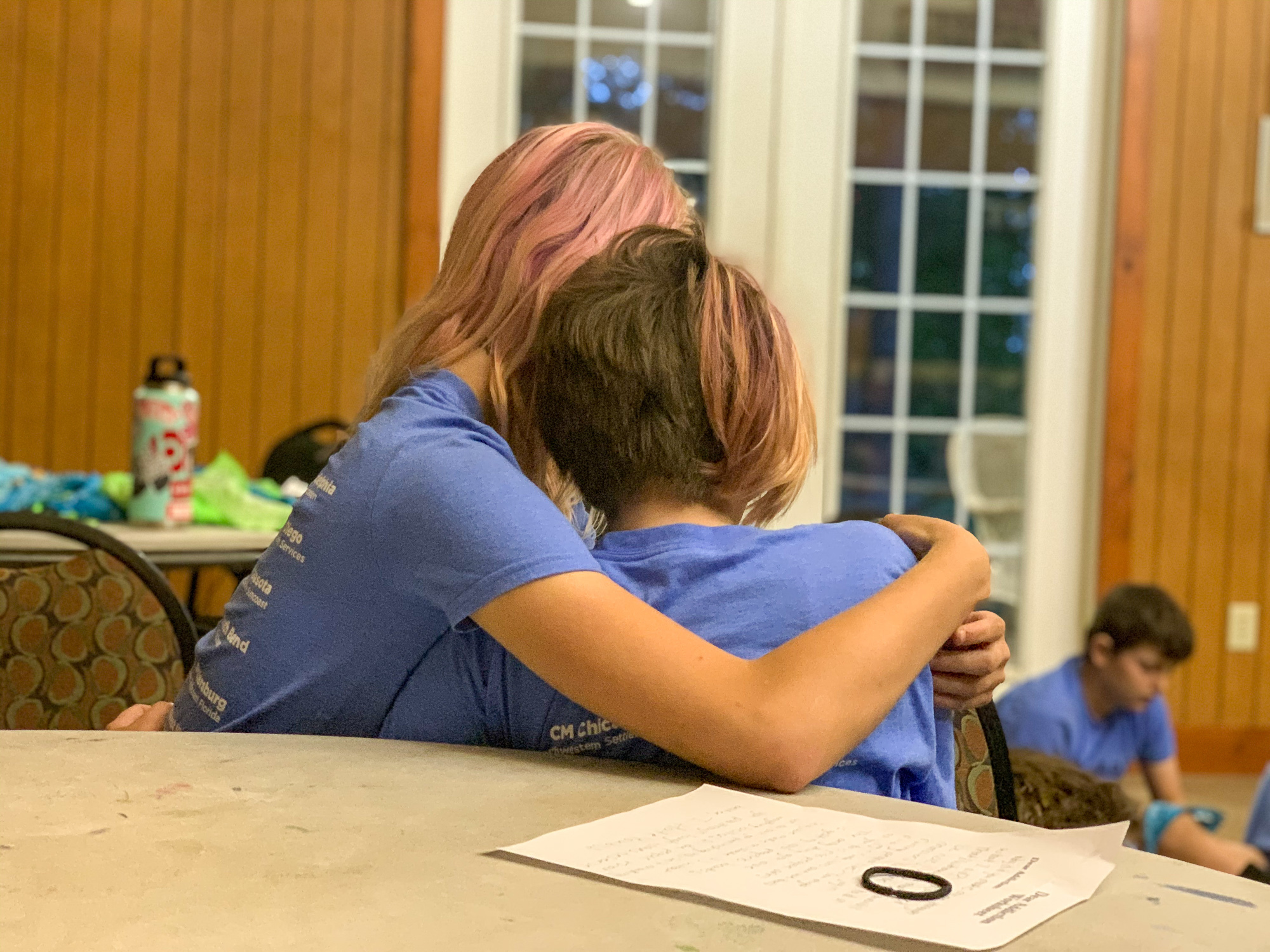 Two 12-year-olds comfort each other while sharing stories about their families. Some say it's only at camp that they don't feel alone because they meet other children in their situation. Some children have seen their parents overdose and some have had to call 911. Many have been taken away to foster care multiple times. (Courtesy of Jared Case)