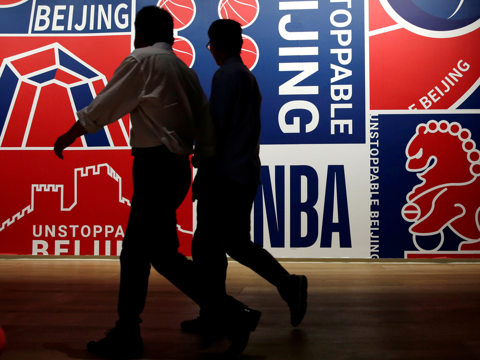 Men walk past a poster at an NBA exhibition in Beijing on Oct. 8. (Jason Lee/Reuters)