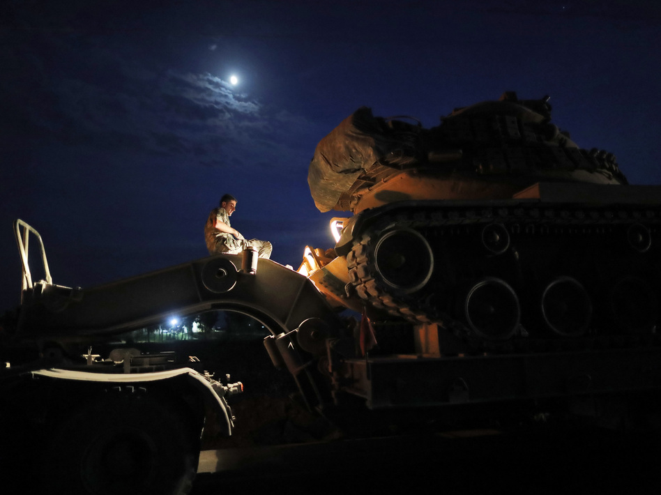 A Turkish army officer prepares to unload a tank from a truck to its new position on the Turkish side of the border between Turkey and Syria, in Sanliurfa province, southeastern Turkey, on Tuesday. (Lefteris Pitarakis/AP)