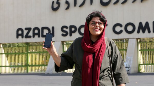 Iranian sports journalist Raha Purbakhsh shows off her ticket to attend a World Cup qualifier in front of Azadi Stadium in Tehran on Tuesday. Iran has essentially banned women from entering the stadium for decades.