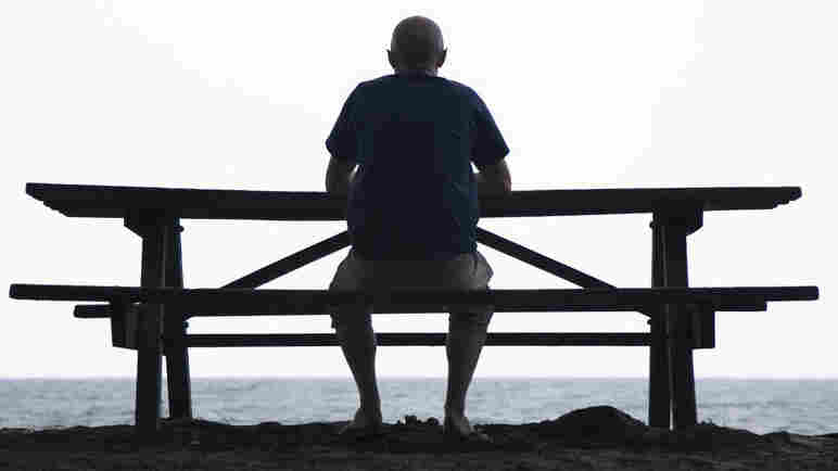 A man sitting by himself at a picnic table.