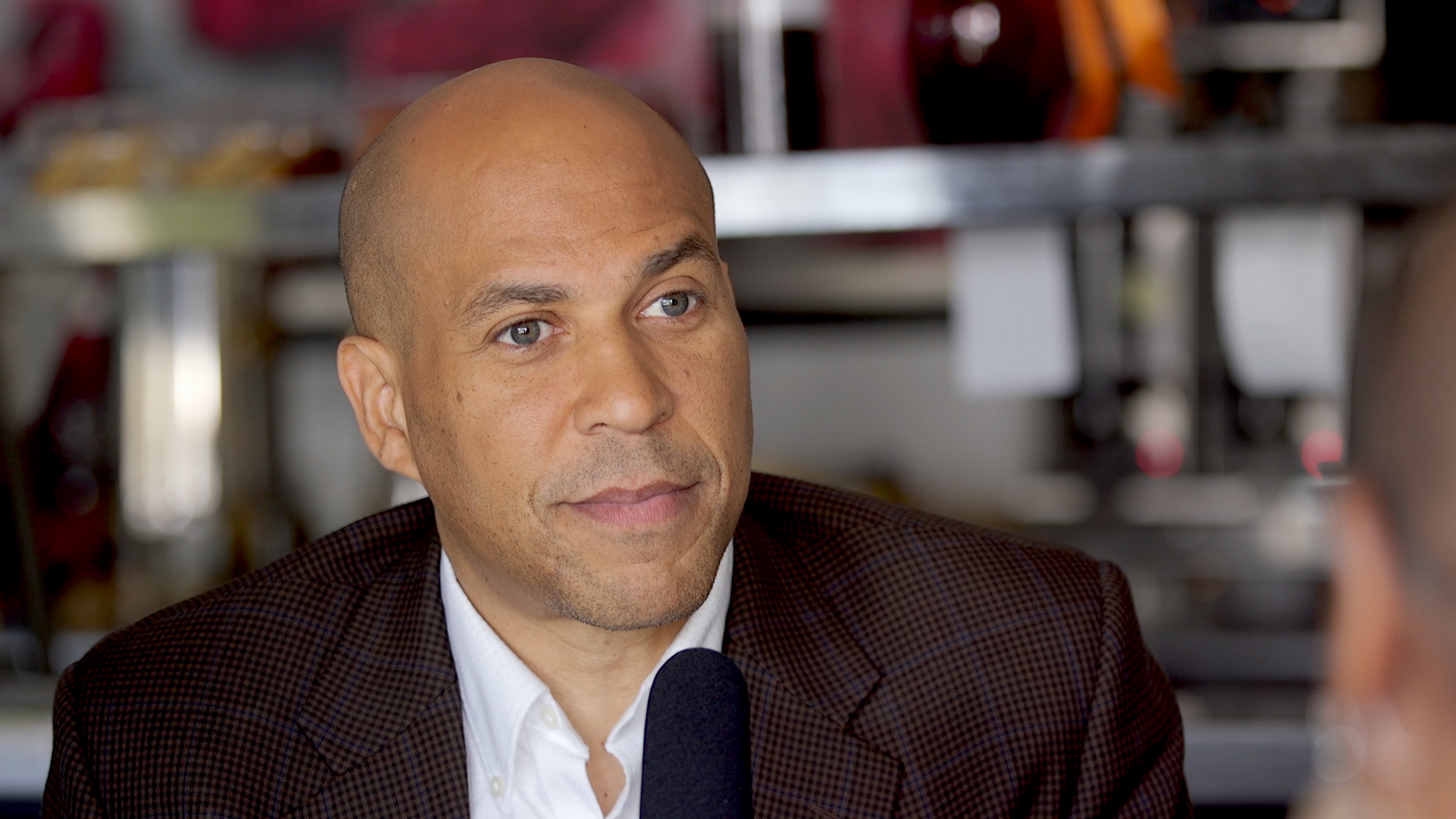 Senator and Democratic presidential candidate Cory Booker listens to a voter during an NPR-moderated discussion with two undecided voters in Booker's hometown of Newark, N.J., on Oct. 12. (NPR)
