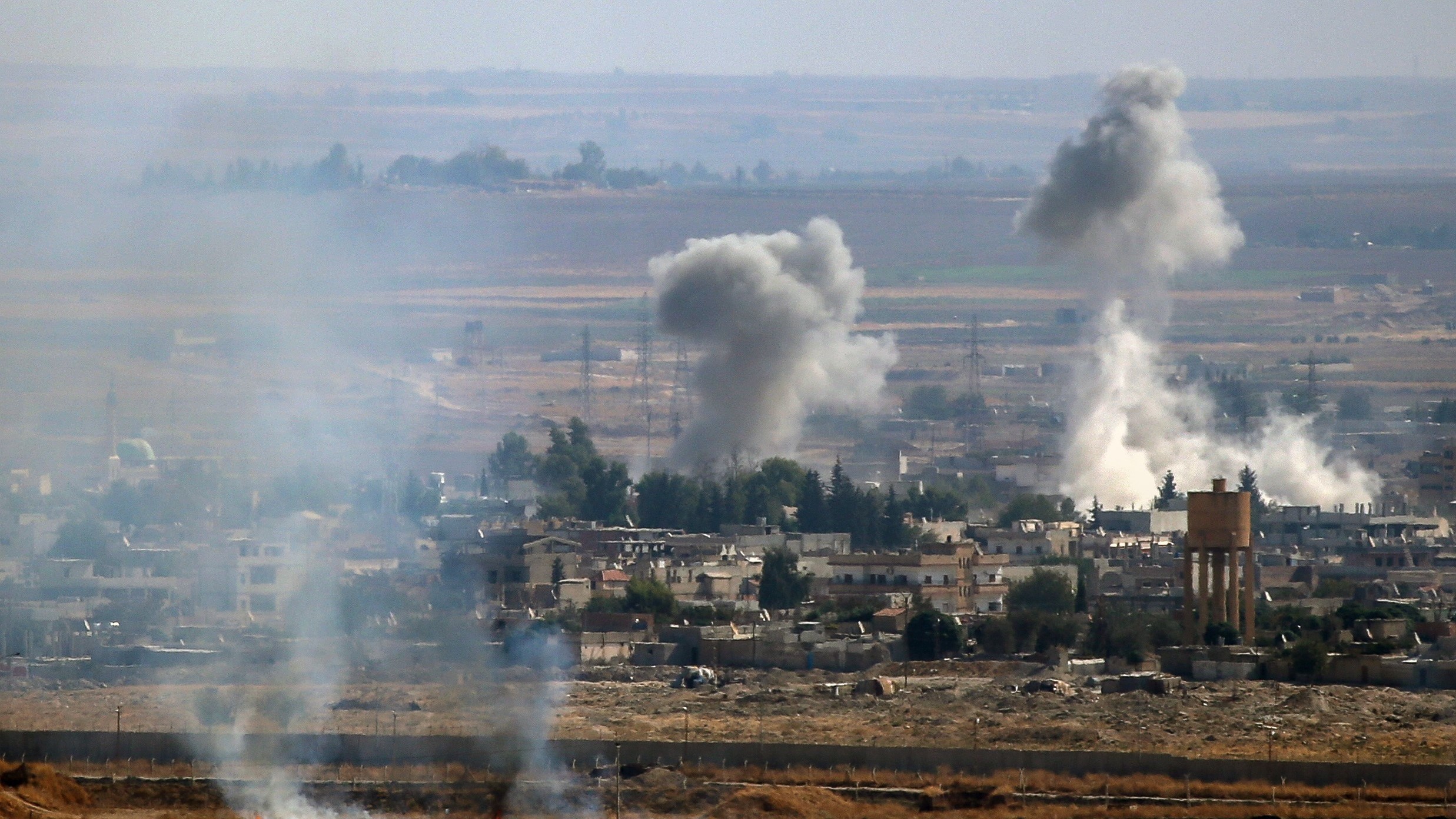 A photo taken from Turkey's Sanliurfa province shows smoke rising after Turkish armed forces hit targets in Ras al-Ain, a town east of the Euphrates River in northern Syria, on Monday. (Anadolu Agency via Getty Images)