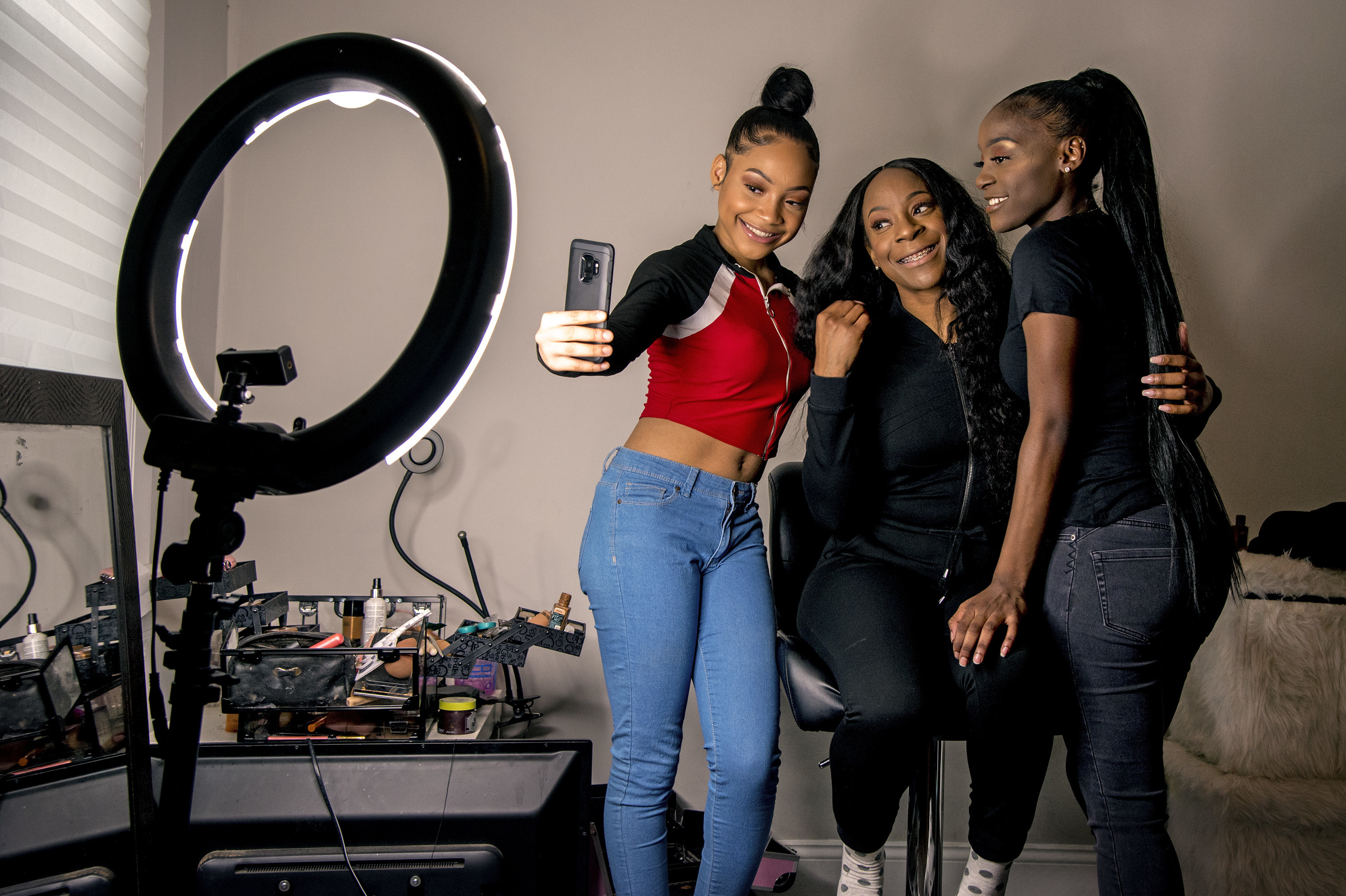 Years ago, Portia Smith (center) was afraid to seek care for her postpartum depression because she feared child welfare involvement. She and her daughters Shanell Smith (right), 19, and Najai Jones Smith (left), 15, pose for a selfie in February after makeup artist Najai made up everyone as they were getting ready at home to go to a movie together. (Philadelphia Inquirer)