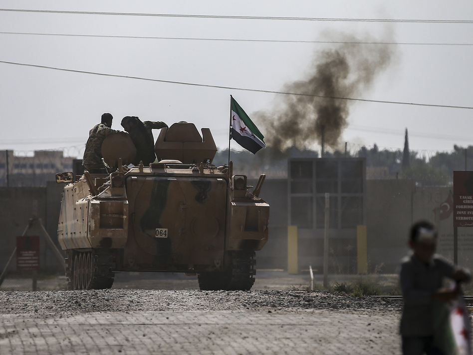 Fighting continued early Friday in a northeast Syrian border town at the center of the fight between Turkey and Kurdish forces, despite a U.S.-brokered cease-fire that went into effect overnight. (Emrah Gurel/AP)