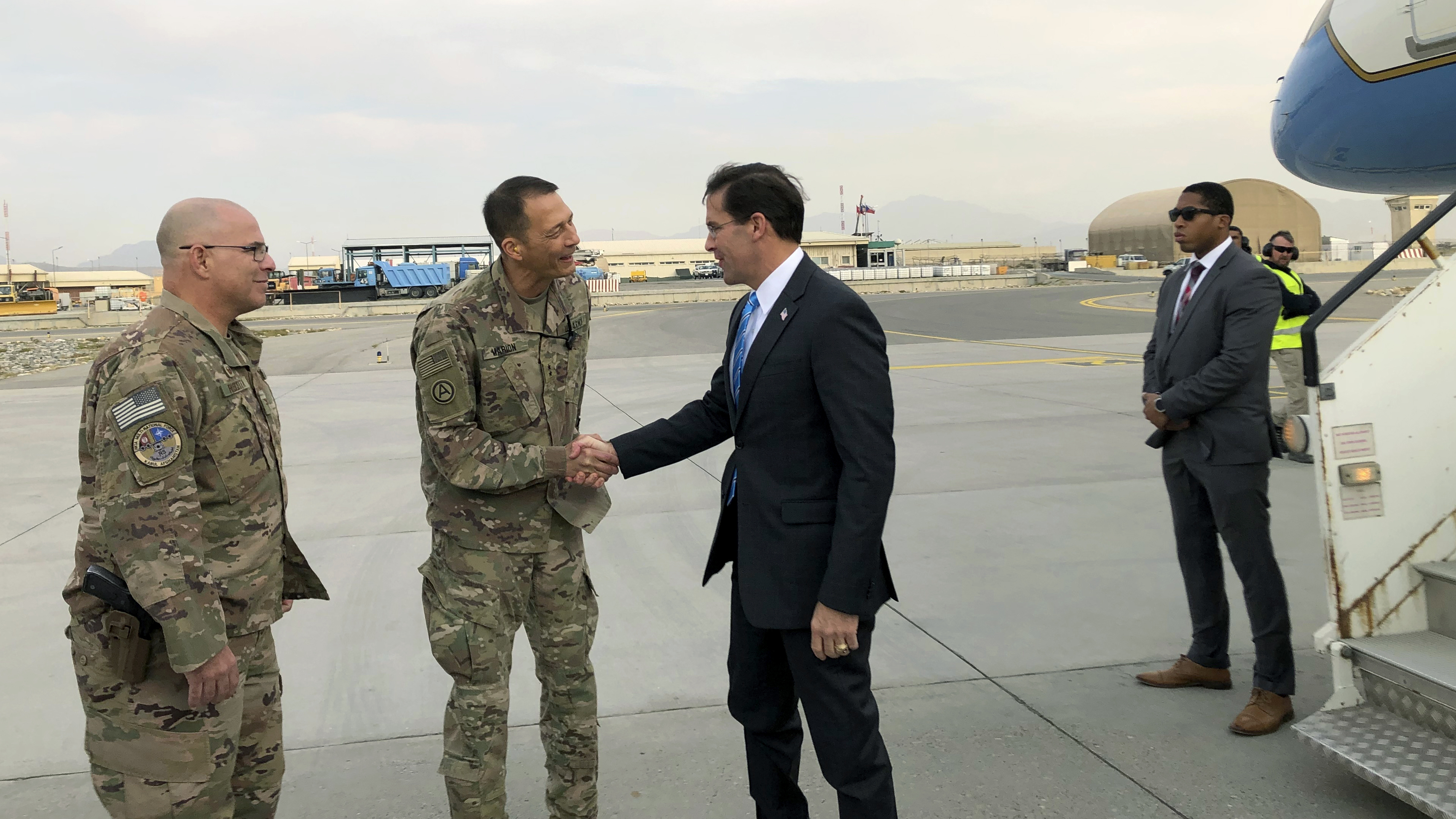 U.S. Defense Secretary Mark Esper (center), is greeted by U.S. military personnel upon arriving in Kabul, Afghanistan, on Sunday.