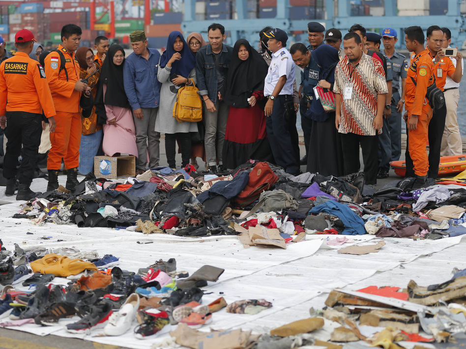 Relatives of passengers of the crashed Lion Air jet check personal belongings retrieved from the waters where the airplane crashed, at Tanjung Priok Port in Jakarta, Indonesia, last October. (Tatan Syuflana/AP)