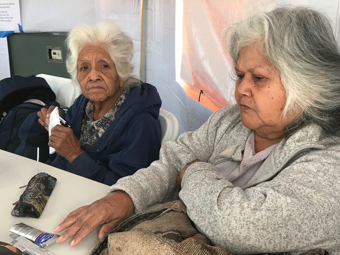 During recent blackouts in California, people like Fern Brown (left) and her sister, Lavina Suehead, came to a pop-up community center at the Auburn, Calf., fairgrounds to use electricity. Brown, 81, needed a treatment for her chronic lung condition. (California Healthline)