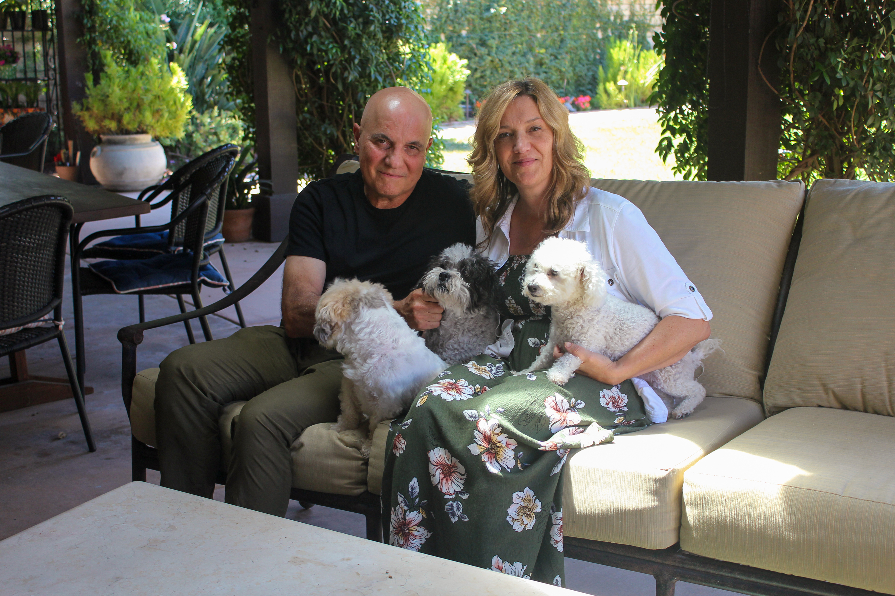 Tom and Dana Saputo sit in their backyard with their three dogs. Tom Saputo's double-lung transplant was fully covered by insurance, but he was responsible for an $11,524.79 portion of the charge for an air ambulance ride. (KHN)