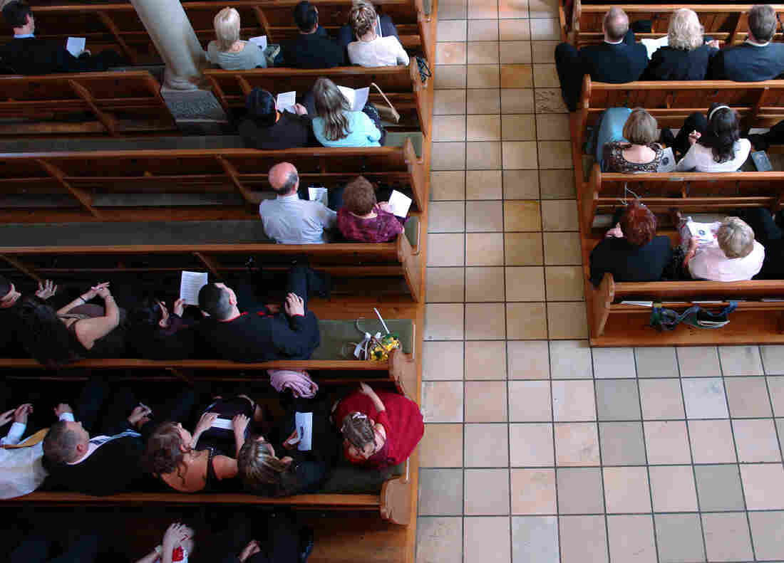 People sitting in the pews of a house of worship.