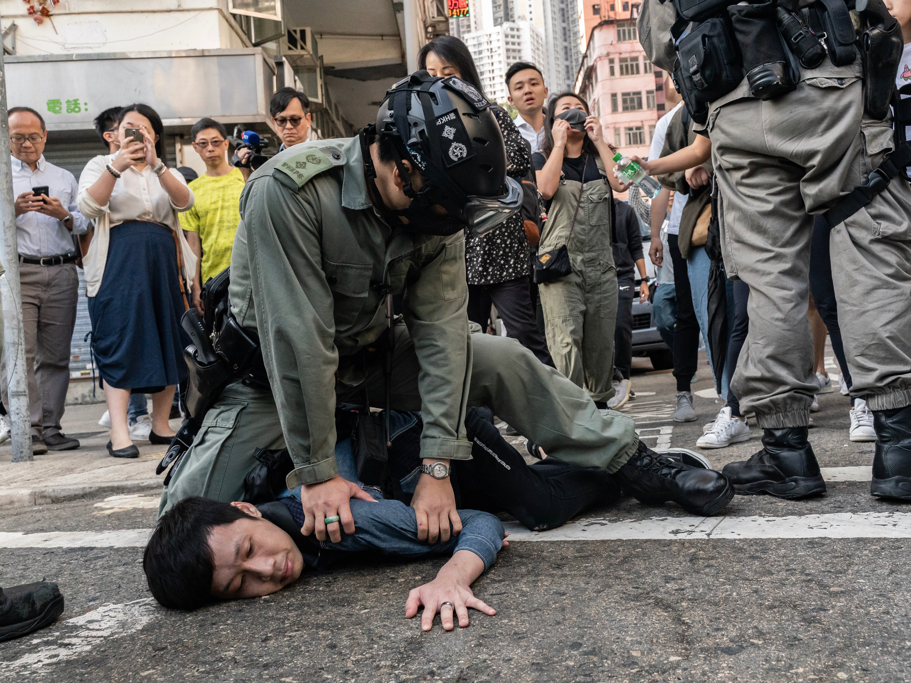 Riot police detain a pro-democracy protester in Hong Kong on Monday, a day when anti-government protesters had organized a general strike.
